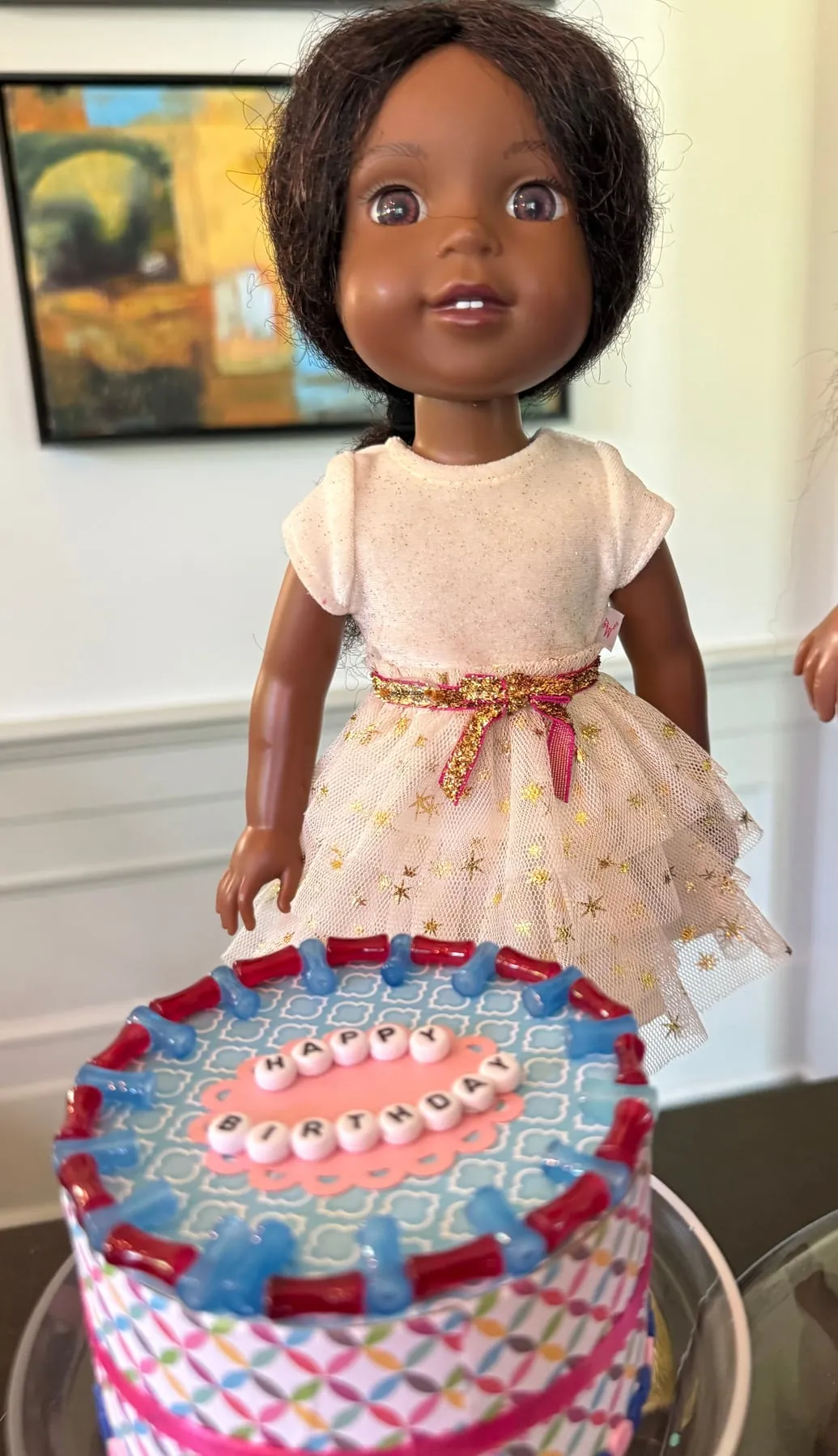 An American Girl doll beside a handmade mini birthday cake craft.