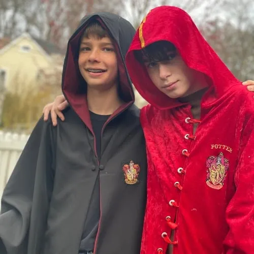Two campers in Hogwarts robes smile at the camera.