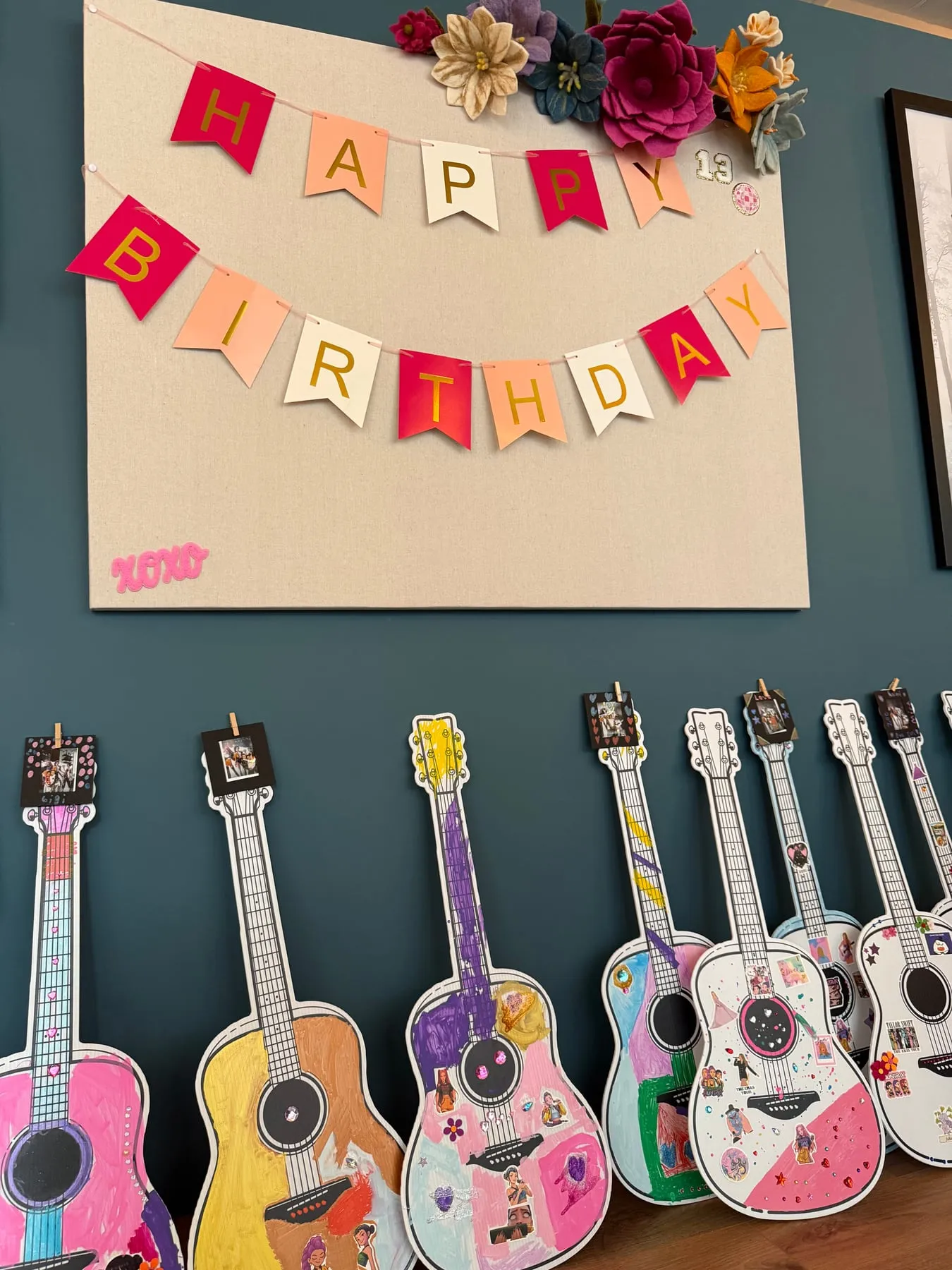 Decorated guitars hang under a Happy Birthday banner in the studio.