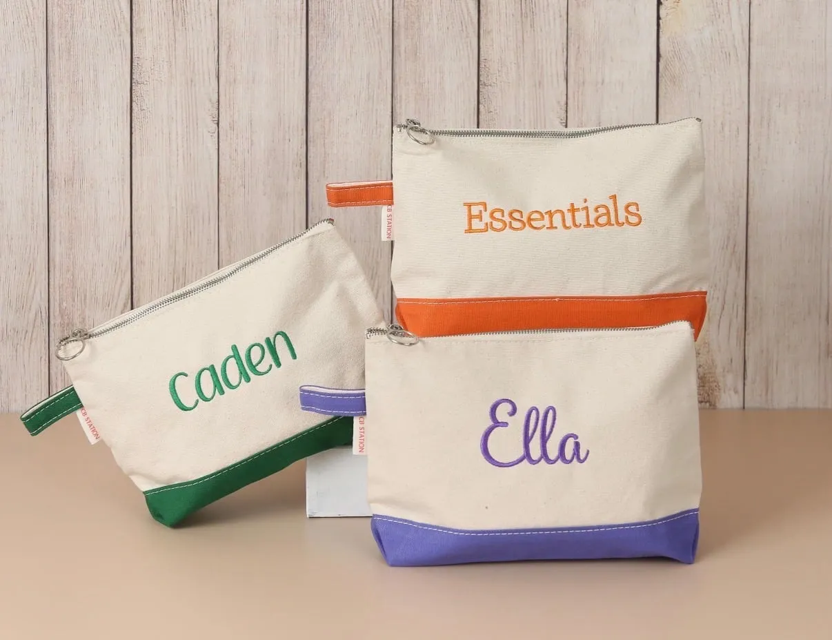 Embroidered zip pouches stitched with the names Caden and Ella.